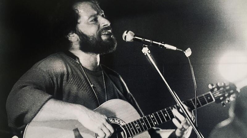 Ein Musiker mit Bart spielt Gitarre und singt leidenschaftlich in ein Mikrofon auf einer Bühne., © Stadtverwaltung Vaihingen an der Enz Ein Musiker mit Bart spielt Gitarre und singt leidenschaftlich in ein Mikrofon auf einer Bühne., © Stadtverwaltung Vaihingen an der Enz