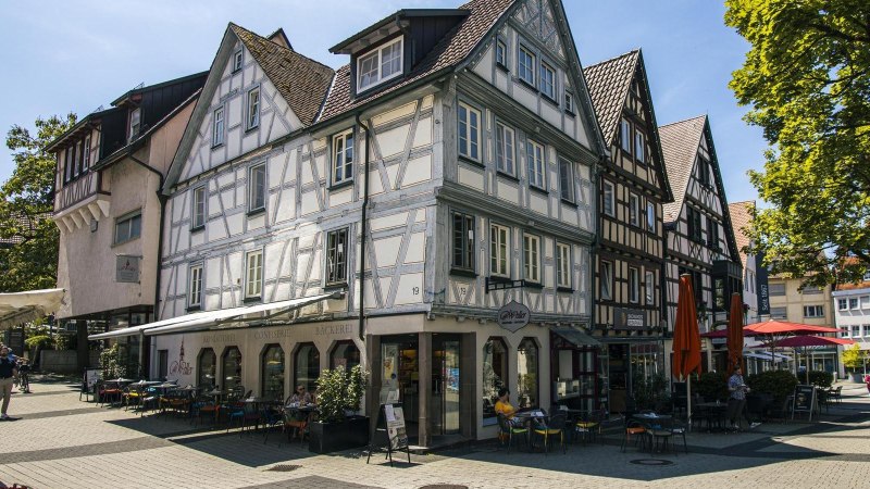 Backnang Altstadt Fachwerk: Fachwerkh&auml;user in der Backnanger Altstadt mit Caf&eacute;terrassen an einem sonnigen Platz., &copy; SMG, Sarah Schmid