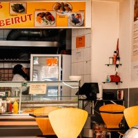 Ein Imbiss mit gelbem Schild 'Imbiss Beirut', leeren Tischen und einer Person hinter der Theke., &copy; SMG, Sarah Schmid