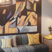 Moderne Lobby mit grauem Sofa, bunten Kissen, abstraktem Wandbild, gelbem Beistelltisch, Pflanze und Stehlampe., © the niu Form - Novum Hospitality Moderne Lobby mit grauem Sofa, bunten Kissen, abstraktem Wandbild, gelbem Beistelltisch, Pflanze und Stehlampe., © the niu Form - Novum Hospitality