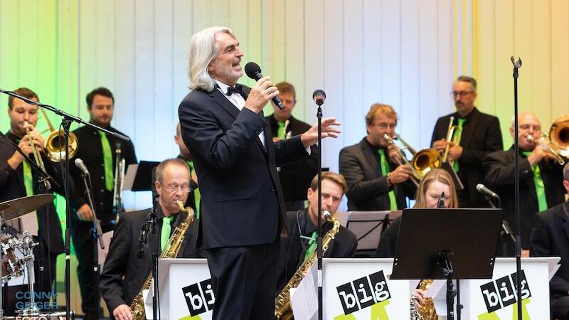 Ein S&auml;nger im Anzug performt mit einer Big Band auf der B&uuml;hne. Die Musiker spielen verschiedene Blasinstrumente., &copy; Stadtverwaltung Kirchheim unter Teck - Kulturring
