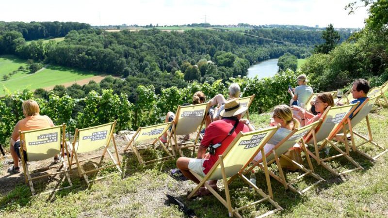 Menschen entspannen in Liegest&uuml;hlen auf einem H&uuml;gel mit Blick auf eine gr&uuml;ne Flusslandschaft bei den Ludwigsburger Steillagentagen., &copy; Tourismus & Events Ludwigsburg