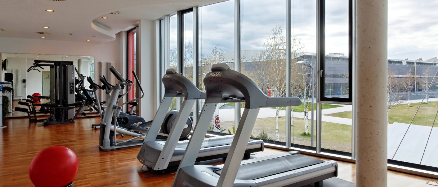 Moderner Fitnessraum im Hilton Garden Inn mit Laufbändern, Fitnessgeräten und großen Fenstern mit Blick nach draußen., © Hilton Garden Inn Stuttgart Neckarpark Moderner Fitnessraum im Hilton Garden Inn mit Laufbändern, Fitnessgeräten und großen Fenstern mit Blick nach draußen., © Hilton Garden Inn Stuttgart Neckarpark