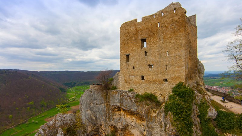 Die Ruine Reussenstein thront auf einem Felsen, umgeben von grünen Hügeln und einem weiten Tal. Der Himmel ist bewölkt., © SMG Mende