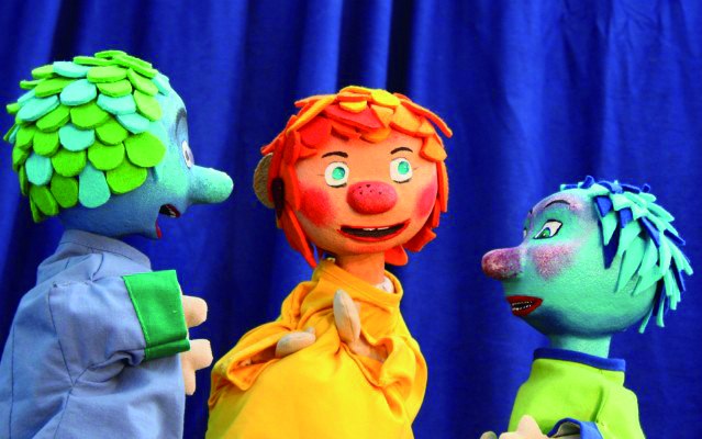 Drei bunte Puppen mit roten, grünen und blauen Haaren stehen vor einem blauen Vorhang und scheinen miteinander zu interagieren., © Für die Bildrechte: Amt für Medien und Kommunikation Schwäbisch Gmünd Drei bunte Puppen mit roten, grünen und blauen Haaren stehen vor einem blauen Vorhang und scheinen miteinander zu interagieren., © Für die Bildrechte: Amt für Medien und Kommunikation Schwäbisch Gmünd