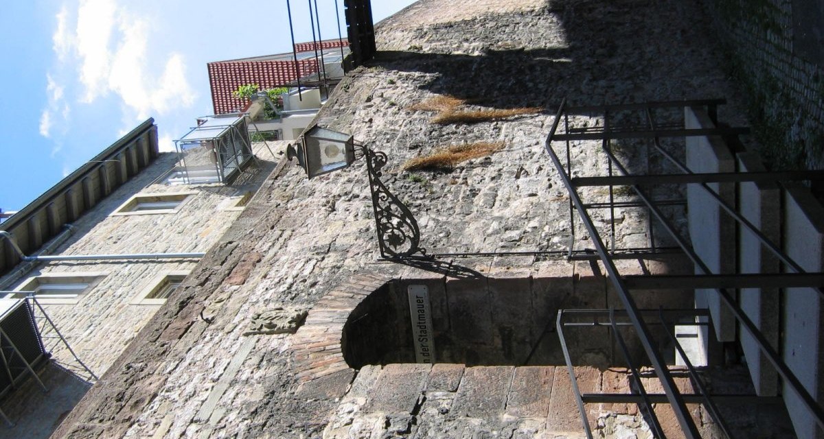 Alte Stadtmauer mit Laterne und Treppe, daneben moderne Gebäude. Der Himmel ist blau mit wenigen Wolken., © Land der 1000 Hügel - Kraichgau-Stromberg Alte Stadtmauer mit Laterne und Treppe, daneben moderne Gebäude. Der Himmel ist blau mit wenigen Wolken., © Land der 1000 Hügel - Kraichgau-Stromberg