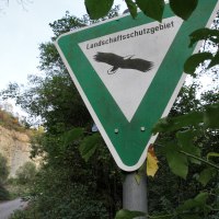 Schild 'Landschaftsschutzgebiet' mit Vogelmotiv, umgeben von Bäumen. Ein Weg führt durch die grüne Landschaft im Hintergrund., © Remstal Tourismus e.V. Schild 'Landschaftsschutzgebiet' mit Vogelmotiv, umgeben von Bäumen. Ein Weg führt durch die grüne Landschaft im Hintergrund., © Remstal Tourismus e.V.