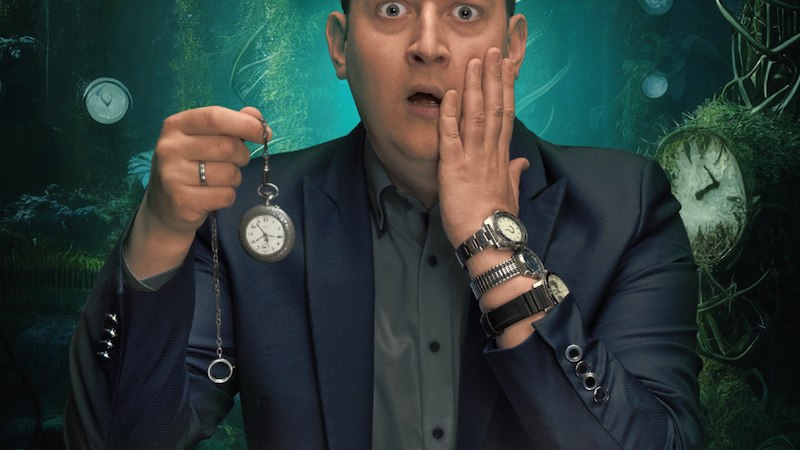 Ein Mann in einem Anzug h&auml;lt eine Taschenuhr und schaut &uuml;berrascht. Im Hintergrund sind viele Uhren in einem mystischen, gr&uuml;nen Wald zu sehen., &copy; Mauerwerk GmbH