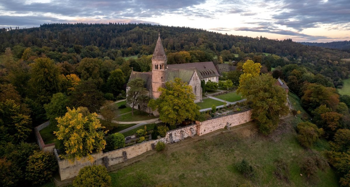 Luftaufnahme des Klosters Lorch, umgeben von herbstlichen Bäumen und Hügeln unter einem bewölkten Himmel., © Thomas Zehnder Luftaufnahme des Klosters Lorch, umgeben von herbstlichen Bäumen und Hügeln unter einem bewölkten Himmel., © Thomas Zehnder