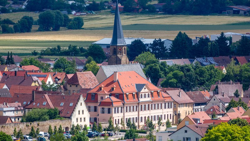 Panoramablick auf Bönnigheim mit einer Kirche im Zentrum, umgeben von roten Dächern und Fachwerkhäusern, eingebettet in eine grüne Landschaft., © Stuttgart-Marketing GmbH