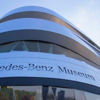 Das Mercedes-Benz Museum zeigt seine moderne Architektur mit geschwungenen Linien und Glasfassaden unter einem blauen Himmel., © Stuttgart-Marketing GmbH Achim Mende