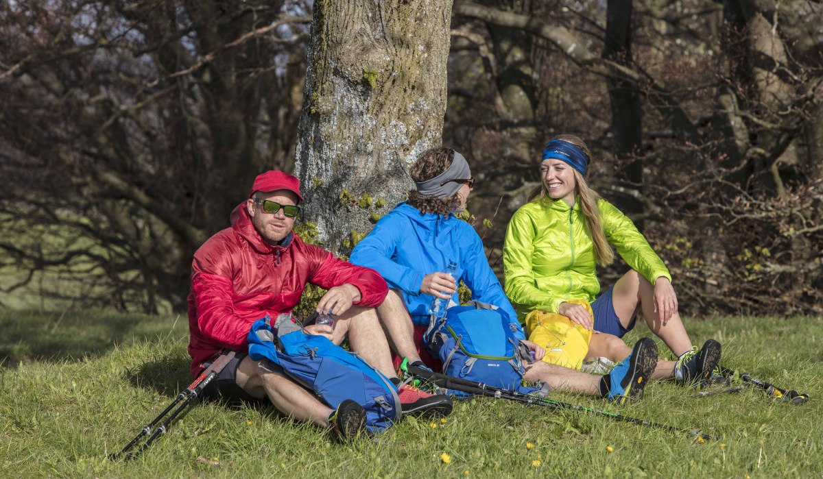 Drei Personen in bunter Outdoor-Kleidung sitzen auf einer Wiese unter einem Baum und machen eine Pause. Sie haben Rucksäcke und Wanderstöcke dabei., © Schwäbische Alb Tourismusverband e.V. Drei Personen in bunter Outdoor-Kleidung sitzen auf einer Wiese unter einem Baum und machen eine Pause. Sie haben Rucksäcke und Wanderstöcke dabei., © Schwäbische Alb Tourismusverband e.V.