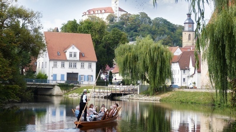Ein Stocherkahn mit Passagieren gleitet auf einem Fluss entlang, umgeben von malerischen Geb&auml;uden und einem Kirchturm im Hintergrund., &copy; Stadtverwaltung Vaihingen an der Enz