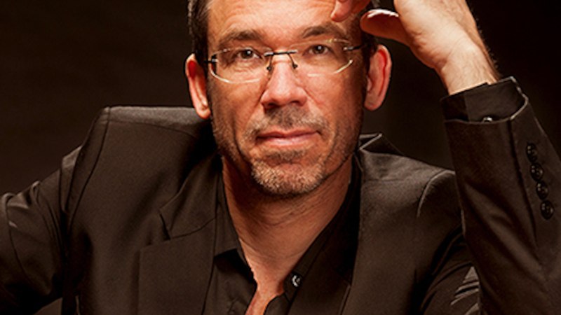 Ein Mann mit Brille und Bart in einem dunklen Anzug, der nachdenklich schaut., © Michael Schütz Konzerte