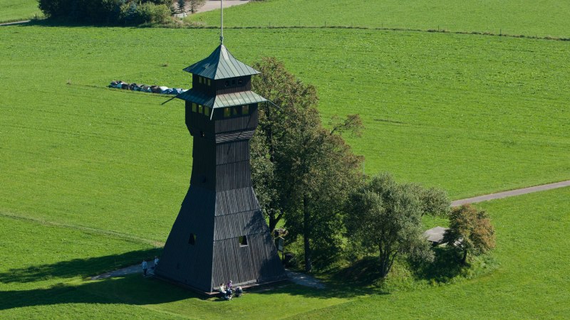 Der Hagbergturm in Gschwend steht auf einer grünen Wiese, umgeben von Bäumen. Der Turm hat ein markantes, spitzes Dach., © FVG Schwäbischer Wald Der Hagbergturm in Gschwend steht auf einer grünen Wiese, umgeben von Bäumen. Der Turm hat ein markantes, spitzes Dach., © FVG Schwäbischer Wald