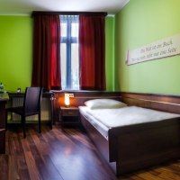 Ein gem&uuml;tliches Einzelzimmer mit gr&uuml;n gestrichenen W&auml;nden, einem Einzelbett, Schreibtisch und Stuhl. Ein roter Vorhang h&auml;ngt am Fenster., &copy; TOMAS