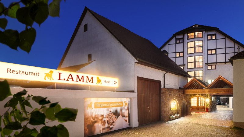 Eingang eines Hotels bei Nacht mit beleuchtetem Schild 'Restaurant Lamm'. Fachwerkhaus im Hintergrund, gepflasterter Weg führt zum Eingang., © Hotel Restaurant Lamm Eingang eines Hotels bei Nacht mit beleuchtetem Schild 'Restaurant Lamm'. Fachwerkhaus im Hintergrund, gepflasterter Weg führt zum Eingang., © Hotel Restaurant Lamm