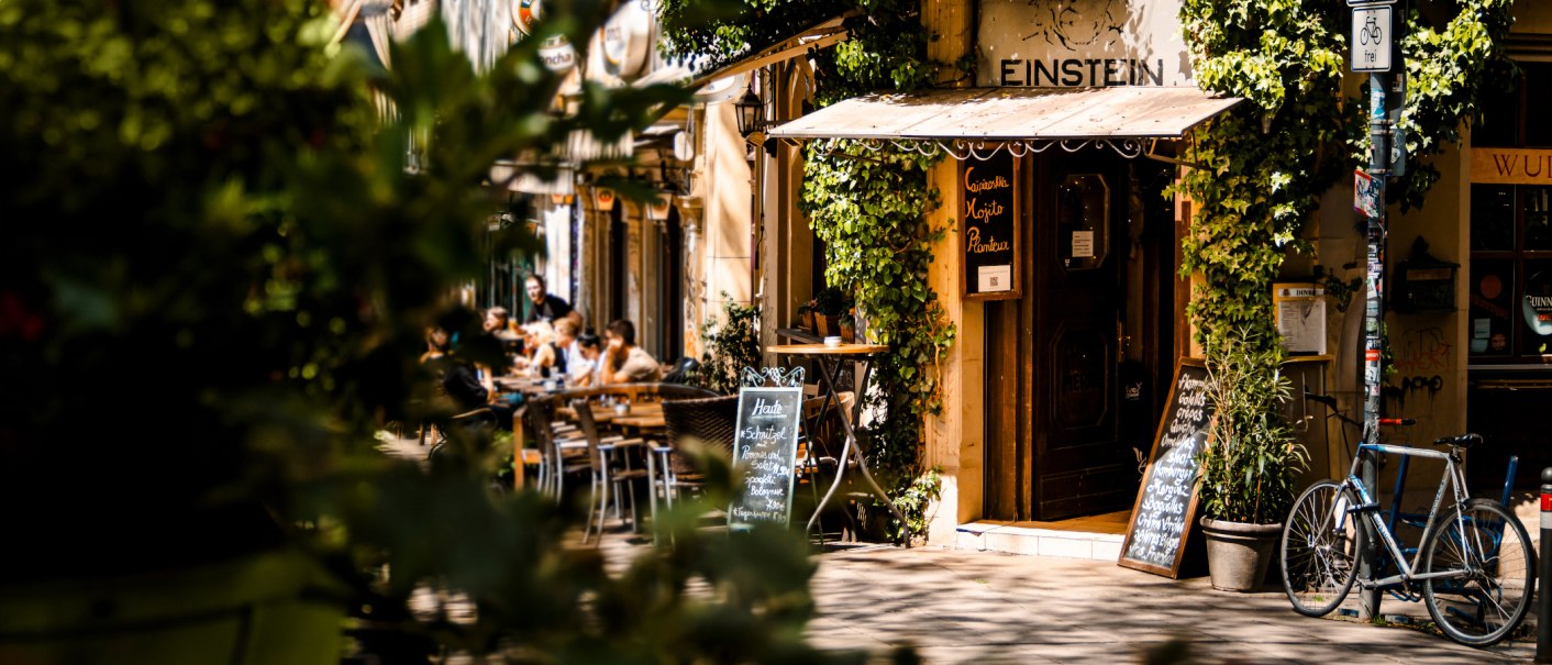 Ein gemütliches Café namens Einstein mit Pflanzen und Fahrrädern. Menschen sitzen draußen und genießen das Wetter., © SMG Stuttgart Marketing GmbH - Sarah Schmid Ein gemütliches Café namens Einstein mit Pflanzen und Fahrrädern. Menschen sitzen draußen und genießen das Wetter., © SMG Stuttgart Marketing GmbH - Sarah Schmid