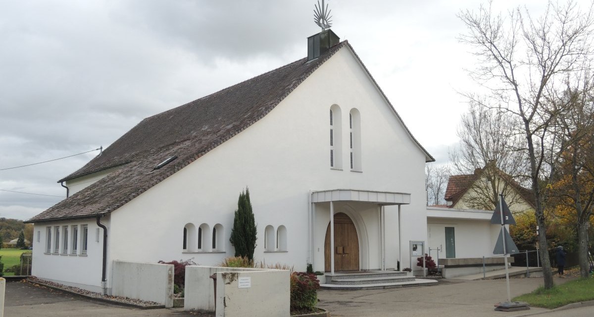 Weiße Kirche mit spitzem Dach und Kreuz, umgeben von Bäumen und Gehweg. Der Himmel ist bewölkt., © Land der 1000 Hügel - Kraichgau-Stromberg Weiße Kirche mit spitzem Dach und Kreuz, umgeben von Bäumen und Gehweg. Der Himmel ist bewölkt., © Land der 1000 Hügel - Kraichgau-Stromberg