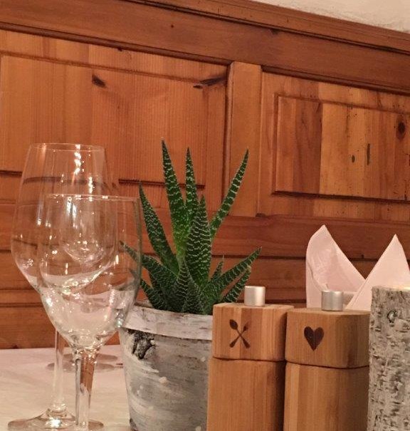 Tisch in einem Restaurant mit Weingläsern, einer kleinen Pflanze und Holzgewürzstreuern vor einer Holzwand., © TOMAS Tisch in einem Restaurant mit Weingläsern, einer kleinen Pflanze und Holzgewürzstreuern vor einer Holzwand., © TOMAS