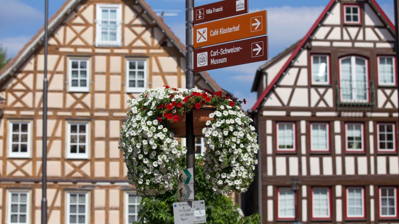 Fachwerkh&auml;user auf dem Marktplatz von Murrhardt mit einem Wegweiser und bl&uuml;hendem Blumenschmuck im Vordergrund., &copy; Stuttgart-Marketing GmbH, Achim Mende
