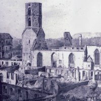 Eine Kirche und umliegende Geb&auml;ude zeigen schwere Sch&auml;den nach dem Stadtbrand von 1868. Ruinen und zerst&ouml;rte D&auml;cher sind sichtbar., &copy; Kirchenbezirk Schw&auml;bisch Hall-Gaildorf