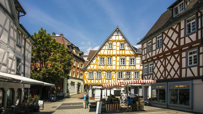 Fachwerkhäuser in der Altstadt von Backnang, umgeben von Marktständen und Passanten bei sonnigem Wetter., © Stuttgart-Marketing GmbH, Sarah Schmid