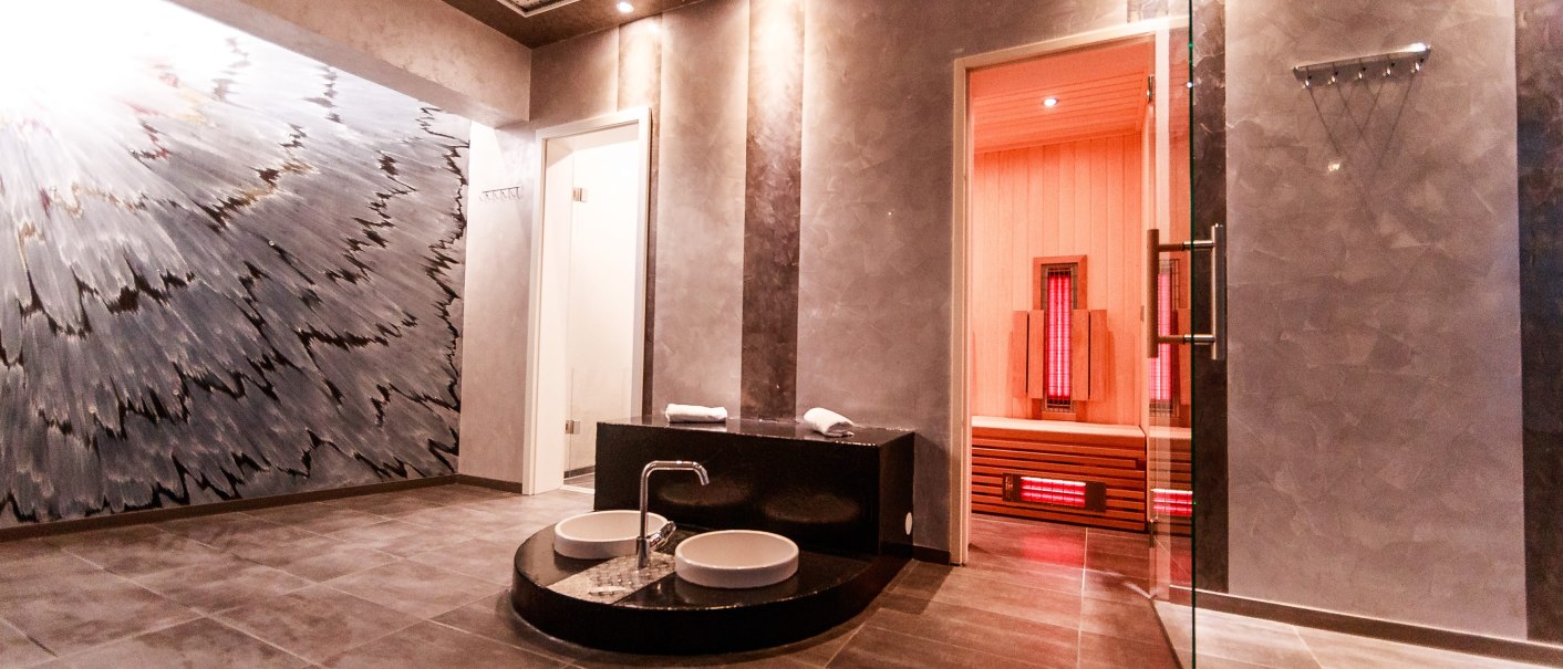 Moderner Saunaraum mit Infrarotsauna, stilvoller Wandkunst und zwei Waschbecken. Die Beleuchtung ist warm und einladend., © Plaza Residence Stuttgart-Ditzingen Moderner Saunaraum mit Infrarotsauna, stilvoller Wandkunst und zwei Waschbecken. Die Beleuchtung ist warm und einladend., © Plaza Residence Stuttgart-Ditzingen