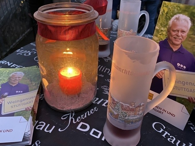 Ein Tisch mit Kerze im Glas, Gl&uuml;hweinbecher und Flyer zur Weingenuss-Tour in Stuttgart., &copy; Weingenuss Stuttgart