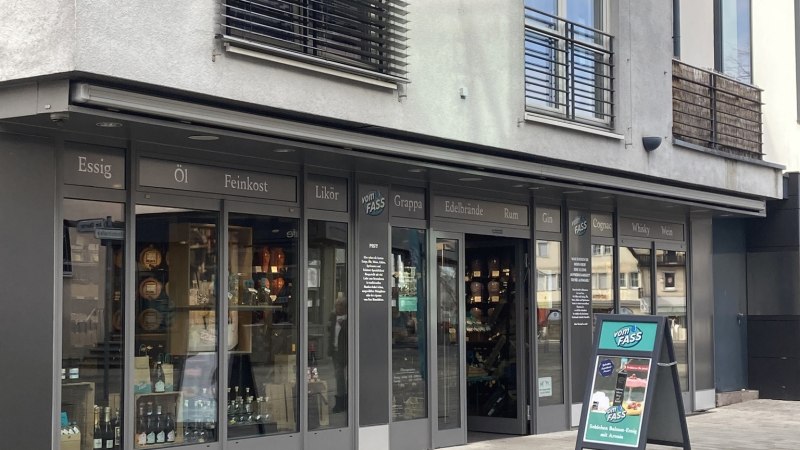 Geschäftsfassade von 'Vom Fass' in Nürtingen mit Schaufenstern und einem Werbeschild auf dem Gehweg., © Lena Besemer