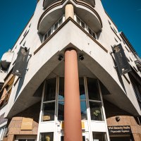 Eckgeb&auml;ude mit Schildern von Takeshiis Lounge und Vivi Beauty Nails, aufgenommen von unten. Stra&szlig;enschild Wagnerstra&szlig;e sichtbar, blauer Himmel im Hintergrund., &copy; SMG Stuttgart Marketing GmbH - Sarah Schmid