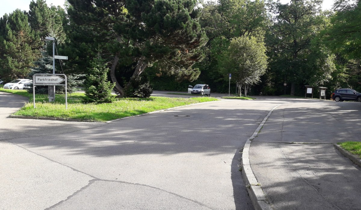 Zufahrt zum Parkplatz am Waldfriedhof. Ein Schild mit der Aufschrift 'Parkfriedhof' steht neben der Straße, umgeben von Bäumen und parkenden Autos., © Natur.Nah. Schönbuch & Heckengäu Zufahrt zum Parkplatz am Waldfriedhof. Ein Schild mit der Aufschrift 'Parkfriedhof' steht neben der Straße, umgeben von Bäumen und parkenden Autos., © Natur.Nah. Schönbuch & Heckengäu