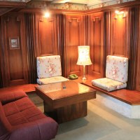 Gem&uuml;tliche Sitzecke mit Holzw&auml;nden, floral gemusterten Kissen, Tisch und Lampe. Ein Telefon steht auf dem Tisch., &copy; Hotel Spahr