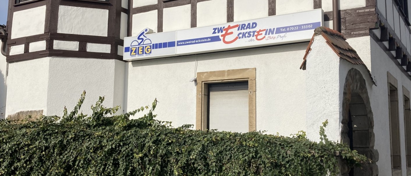 Fachwerkhaus mit Efeu bewachsener Wand und Schild 'Zweirad Eckstein'. Traditionelle Architektur mit Erker und roten Dachziegeln., © Lena Besemer Fachwerkhaus mit Efeu bewachsener Wand und Schild 'Zweirad Eckstein'. Traditionelle Architektur mit Erker und roten Dachziegeln., © Lena Besemer