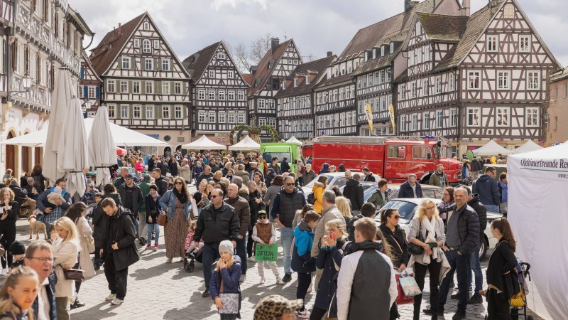 Menschenmenge auf einem belebten Marktplatz mit historischen Fachwerkhäusern und Ständen. Ein rotes Fahrzeug und ein Zelt sind ebenfalls zu sehen., © Stadt Schorndorf Menschenmenge auf einem belebten Marktplatz mit historischen Fachwerkhäusern und Ständen. Ein rotes Fahrzeug und ein Zelt sind ebenfalls zu sehen., © Stadt Schorndorf