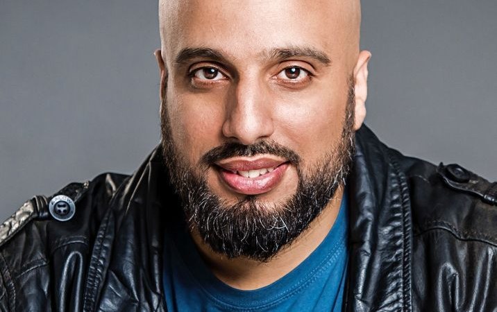 Ein Mann mit Glatze und Bart tr&auml;gt eine Lederjacke und l&auml;chelt in die Kamera. Der Hintergrund ist grau., &copy; Konzertkreis Triangel Compagnia Compostelli e.V.