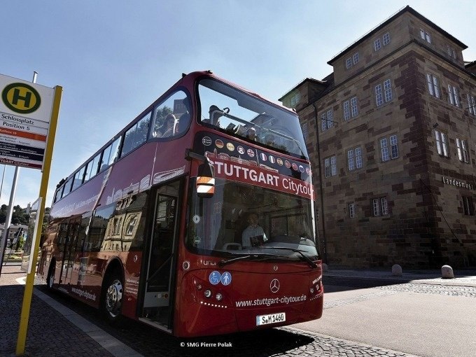 Roter Doppeldeckerbus der Stuttgart Citytour an einer Haltestelle vor einem historischen Gebäude. Menschen sitzen im oberen Deck., © SMG, Pierre Polak Roter Doppeldeckerbus der Stuttgart Citytour an einer Haltestelle vor einem historischen Gebäude. Menschen sitzen im oberen Deck., © SMG, Pierre Polak