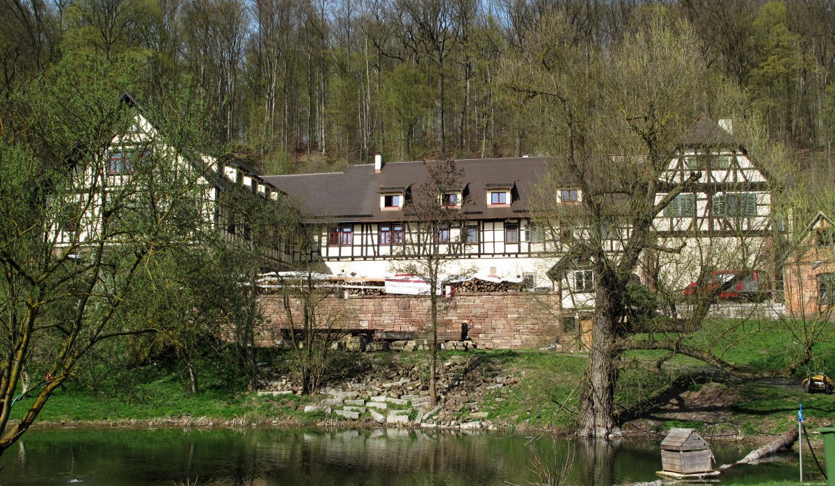 Fachwerkhaus am Waldrand, umgeben von Bäumen. Ein kleiner Teich mit Entenhaus im Vordergrund. Frühlingshafte Atmosphäre., © RadL Leonberg Fachwerkhaus am Waldrand, umgeben von Bäumen. Ein kleiner Teich mit Entenhaus im Vordergrund. Frühlingshafte Atmosphäre., © RadL Leonberg