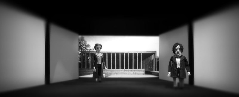 Zwei Puppen stehen in einem modernen, minimalistischen Raum mit geometrischen Formen. Schwarz-Weiß-Fotografie., © LIMA-Theater Zwei Puppen stehen in einem modernen, minimalistischen Raum mit geometrischen Formen. Schwarz-Weiß-Fotografie., © LIMA-Theater