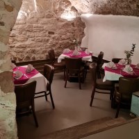 Ein gem&uuml;tlicher Kellerraum mit Steinw&auml;nden und gew&ouml;lbter Decke. Die Tische sind mit wei&szlig;en Tischdecken und roten Servietten dekoriert., &copy; DaInes