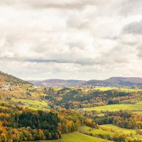 Herbstliche Landschaft mit bunten Wäldern und Hügeln um den Hohenstaufen bei Göppingen. Wolkenverhangener Himmel und Windräder am Horizont., © Stuttgart-Marketing GmbH, Sarah Schmid