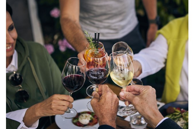 Eine Gruppe von Menschen st&ouml;&szlig;t mit Weingl&auml;sern und einem Cocktail an einem gedeckten Tisch an., &copy; Esslinger Stadtmarketing &amp; Tourismus GmbH