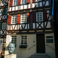 Fachwerkhäuser in Schorndorf mit einer Büste von Gottlieb Daimler im Vordergrund. Sonnenschirme und ein Cafébereich sind ebenfalls zu sehen., © Stuttgart-Marketing GmbH, Sarah Schmid Fachwerkhäuser in Schorndorf mit einer Büste von Gottlieb Daimler im Vordergrund. Sonnenschirme und ein Cafébereich sind ebenfalls zu sehen., © Stuttgart-Marketing GmbH, Sarah Schmid