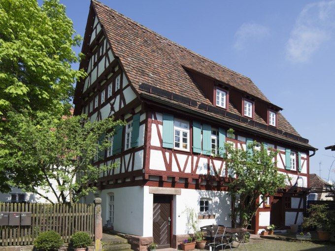 Fachwerkhaus mit grünen Fensterläden, umgeben von Bäumen und Gartenmöbeln. Sonniger Tag mit blauem Himmel., © Stadtverwaltung Weil der Stadt Fachwerkhaus mit grünen Fensterläden, umgeben von Bäumen und Gartenmöbeln. Sonniger Tag mit blauem Himmel., © Stadtverwaltung Weil der Stadt