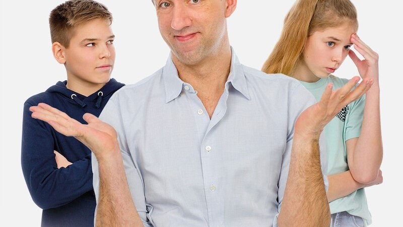 Ein Mann hebt die Schultern, w&auml;hrend ein Junge und ein M&auml;dchen im Hintergrund stehen. Der Junge schaut skeptisch, das M&auml;dchen wirkt nachdenklich., &copy; Mauerwerk GmbH