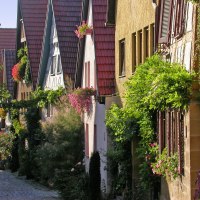 Fachwerkhäuser in Marbach am Neckar mit blühenden Pflanzen und roten Dächern. Die Straße ist von Bäumen und Blumen gesäumt., © Tourismusgemeinschaft Marbach-Bottwartal/Dieter Sukowski Fachwerkhäuser in Marbach am Neckar mit blühenden Pflanzen und roten Dächern. Die Straße ist von Bäumen und Blumen gesäumt., © Tourismusgemeinschaft Marbach-Bottwartal/Dieter Sukowski