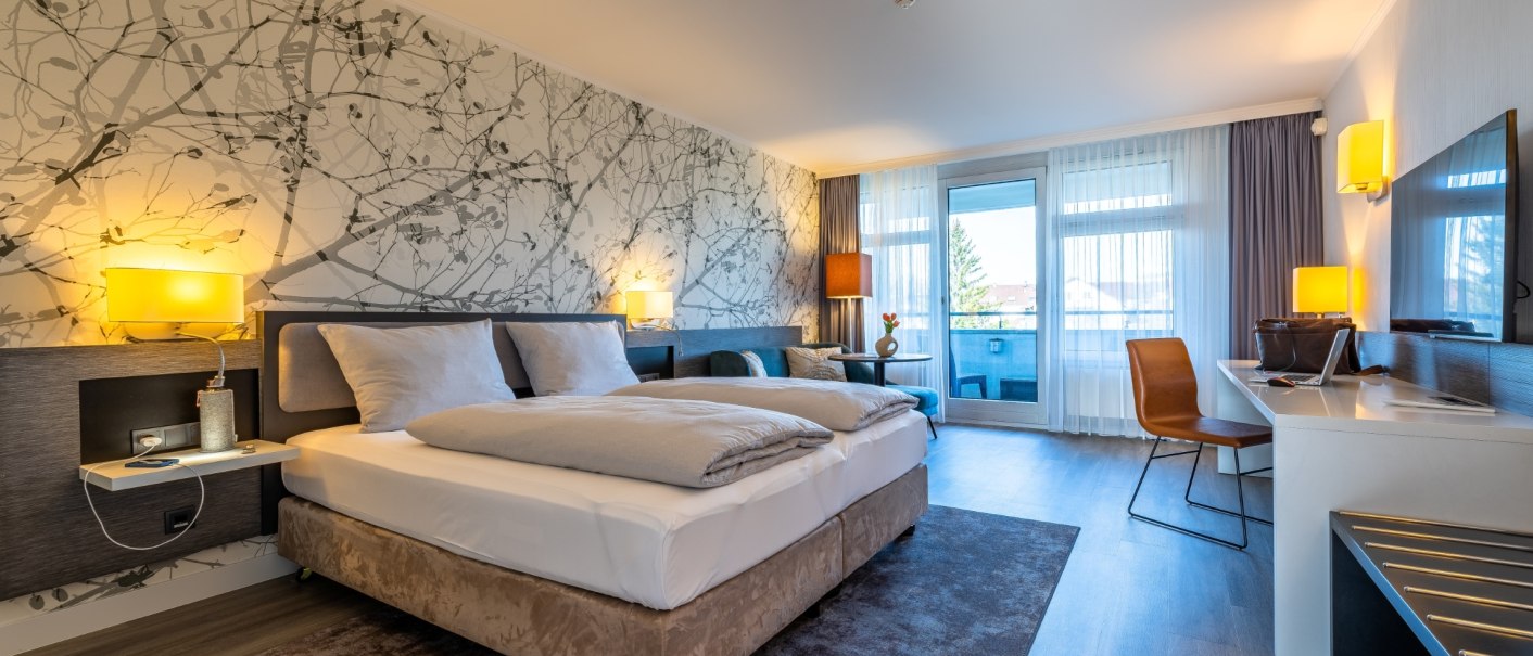 Modernes Hotelzimmer mit Doppelbett, Schreibtisch, Stuhl und Balkon. Helle Farben und stilvolle Wandgestaltung mit Naturmotiv., © MASEVEN Stuttgart SI-Centrum Modernes Hotelzimmer mit Doppelbett, Schreibtisch, Stuhl und Balkon. Helle Farben und stilvolle Wandgestaltung mit Naturmotiv., © MASEVEN Stuttgart SI-Centrum