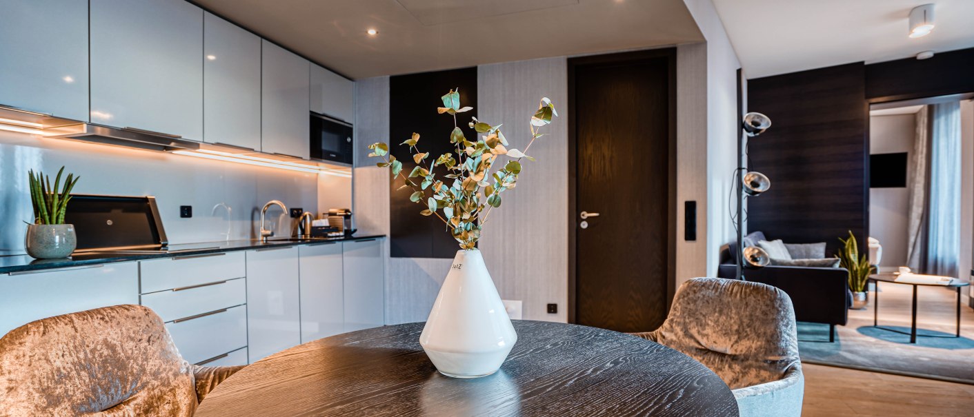 Moderne Suite mit eleganter Küche, rundem Esstisch und gemütlichem Wohnzimmer. Dezente Beleuchtung und stilvolle Dekoration., © CLOUD N°7 APARTMENTS GmbH