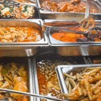 Ein Buffet mit verschiedenen warmen Speisen in Edelstahlbeh&auml;ltern, darunter Bohnen, Gem&uuml;se und gef&uuml;llte Auberginen., &copy; Zauberk&uuml;che, Stuttgart