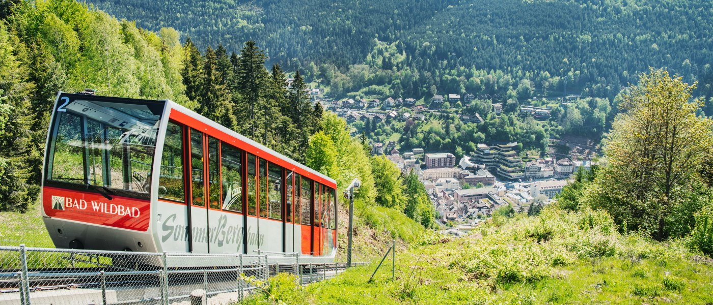 Die Sommerbergbahn in Bad Wildbad f&auml;hrt durch gr&uuml;ne H&auml;nge mit Blick auf den Ort im Tal und dichte W&auml;lder., &copy; Touristik Bad Wildbad Gmbh